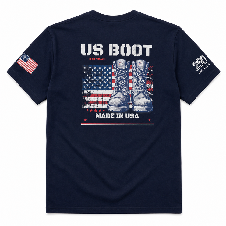 A navy blue short-sleeve t-shirt shown from the back, featuring a graphic print of combat boots over an American flag with the text 'US BOOT' and 'MADE IN USA'. The left sleeve has an American flag print, and the right sleeve features a white '250 AMERICA' logo.