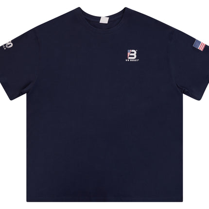 A navy blue short-sleeve crewneck t-shirt with a small white embroidered 'B' logo and 'BREAST' text on the left chest, a small white logo on the right sleeve, and an American flag patch on the left sleeve, shown against a plain white background.
