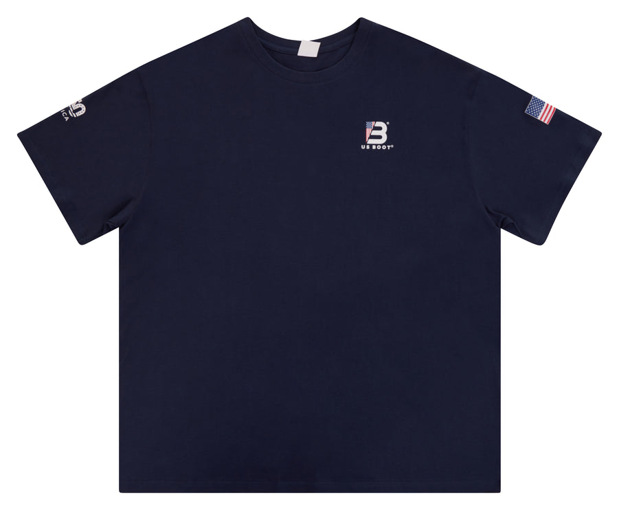 A navy blue short-sleeve crewneck t-shirt with a small white embroidered 'B' logo and 'BREAST' text on the left chest, a small white logo on the right sleeve, and an American flag patch on the left sleeve, shown against a plain white background.