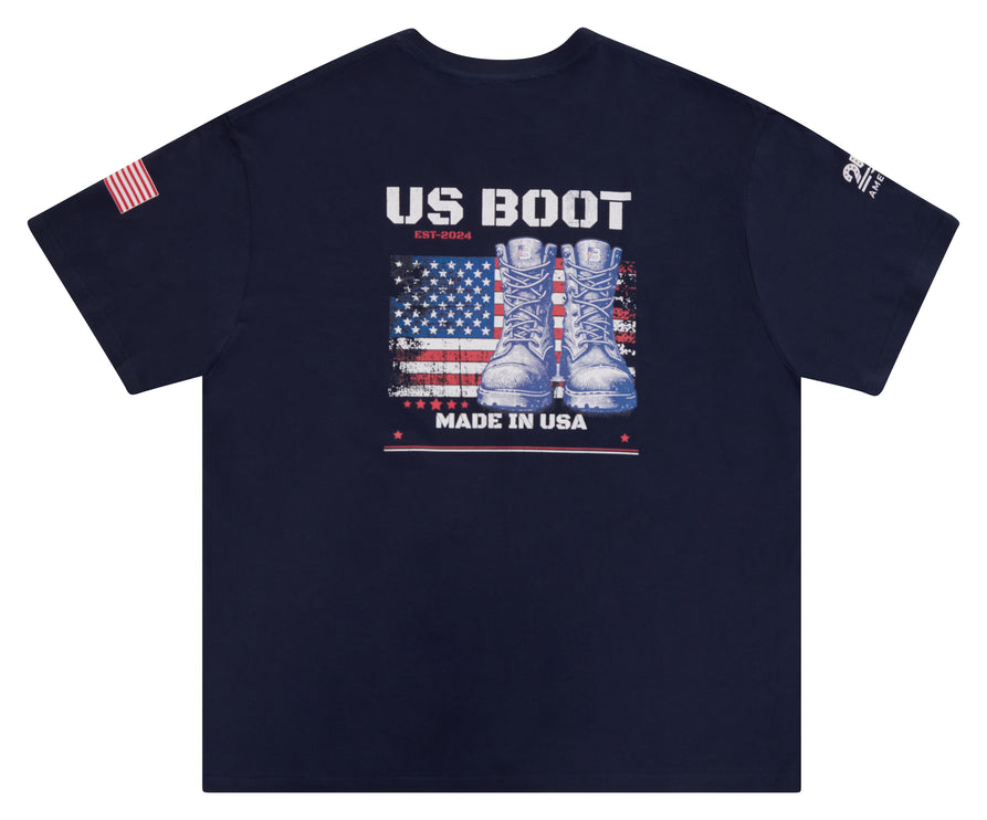 A navy blue short-sleeve t-shirt with a patriotic graphic on the front featuring the text 'US BOOT EST.2025' above a distressed American flag and a pair of combat boots, with 'MADE IN USA' below.