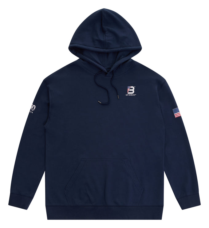 A navy blue pullover hoodie with a kangaroo pocket, featuring a small white and red logo on the left chest, a white graphic on the right sleeve, and a small American flag patch on the left sleeve, shown against a plain white background.